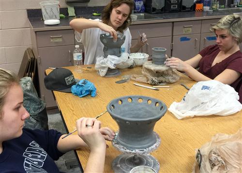 ceramic students working on their Joman inspired creations 
